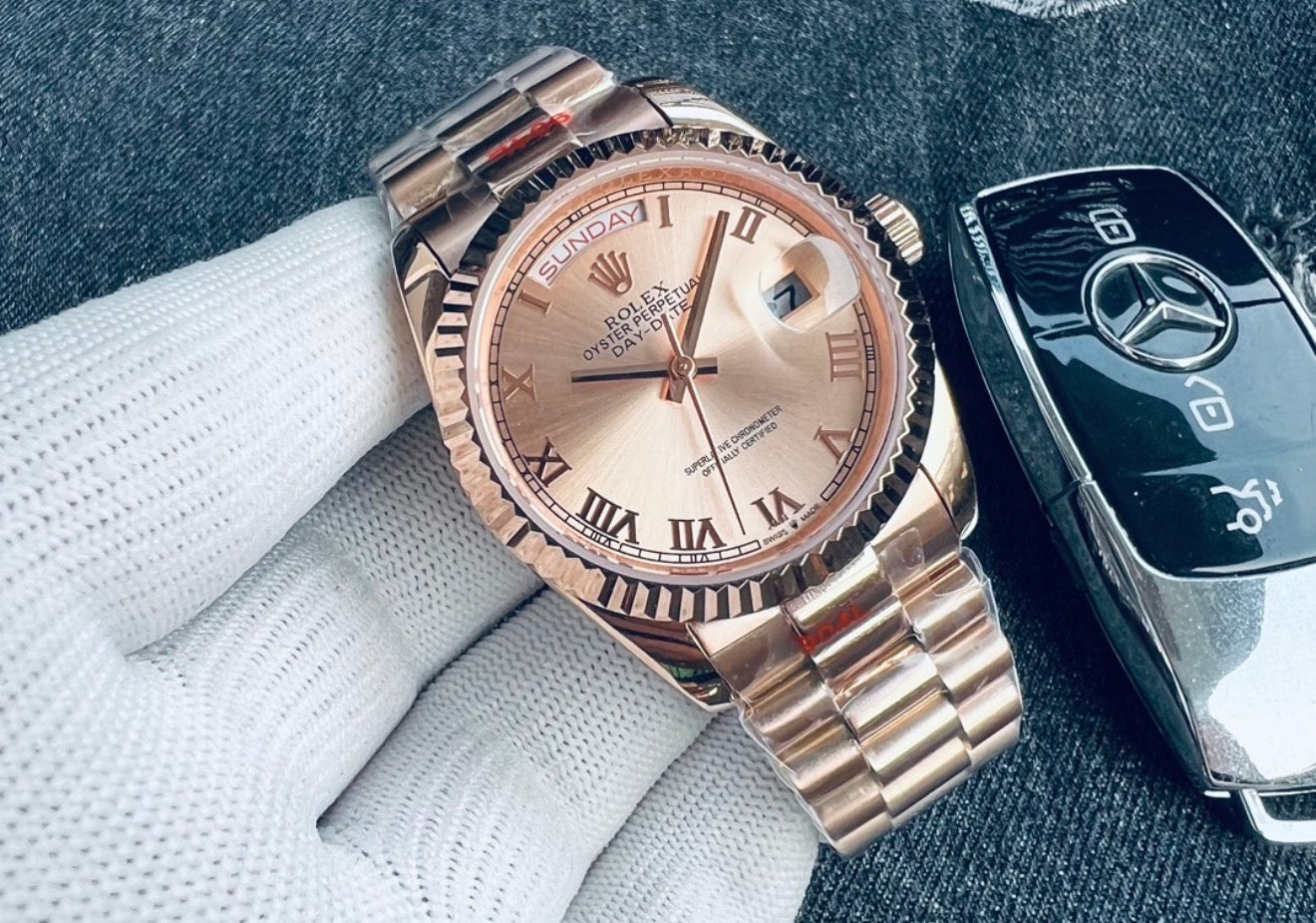 Elegante reloj Rolex Day-Date de oro Everose con una distintiva esfera y números romanos.