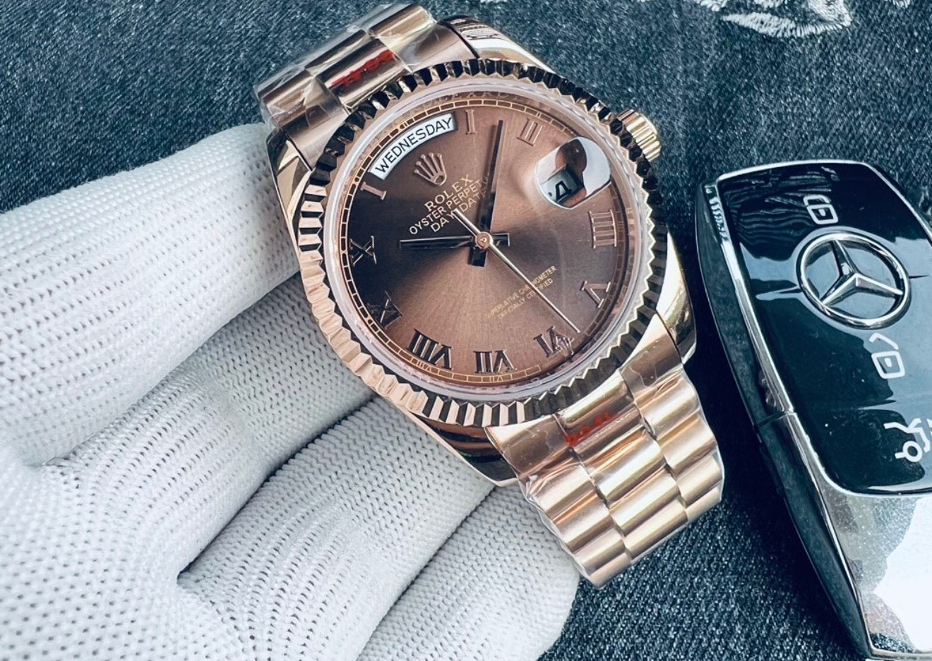 Elegante reloj Rolex Day-Date de oro Everose con una distintiva esfera y números romanos.