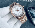 Elegante reloj Rolex Day-Date de oro Everose con una distintiva esfera y números romanos.